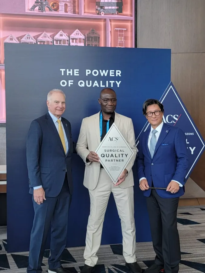 Dr Adama Sanogo tenant la plaque Surgical Quality Partner de l’American College of Surgeons